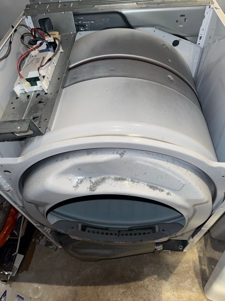 Dryer repair in Toronto — dryer with the top and front panels removed showing the drum inside the cabinet and the control board with its wiring harness